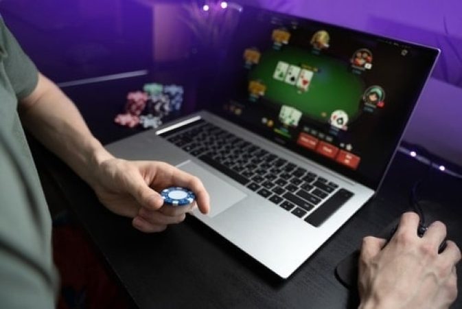 Person playing real money poker via his laptop